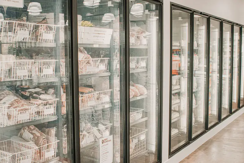 Glass-door freezers along a grocery aisle