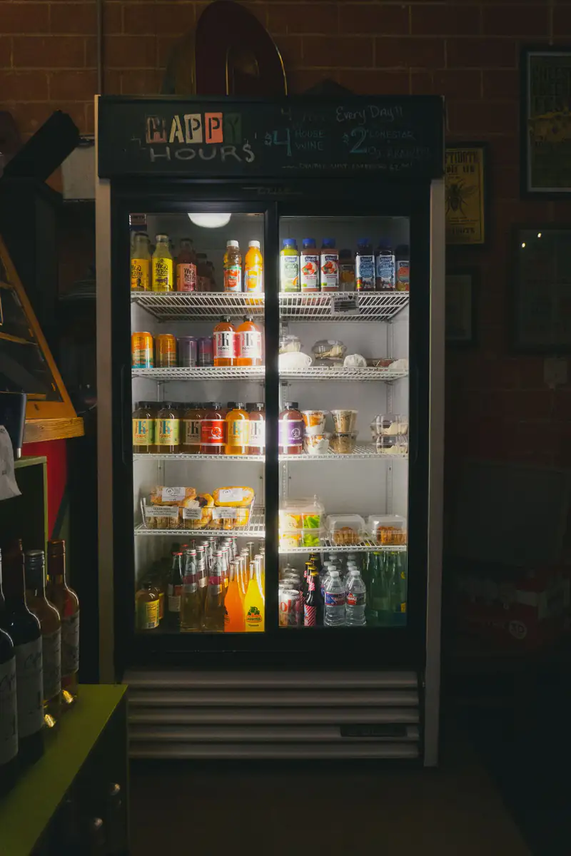 Lit reach-in cooler stocked with drinks