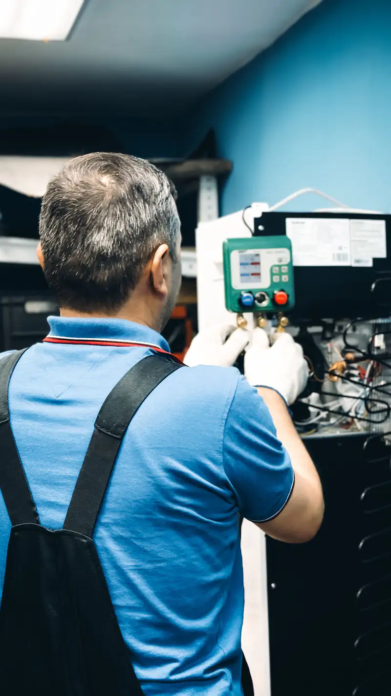 HVAC technician reading manifold gauges
